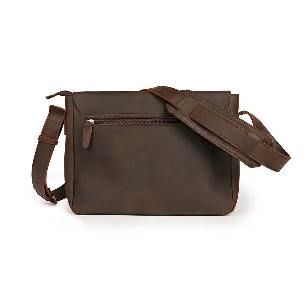 Back view of a dark brown leather shoulder bag with a secure zippered pocket and padded strap for comfort