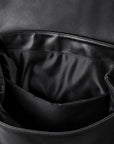 Close-up of the interior of a black leather or full-grain leather bag, showing a spacious open compartment with black lining and stitched edges.