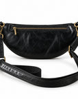 Black leather crescent-shaped crossbody bag with gold-tone hardware and a detachable shoulder strap.