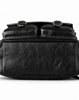 Black textured leather backpack shown from the front, featuring two top flap pockets with gold-tone buckle details.
