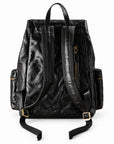 Black leather backpack with gold-tone hardware, shown from the back on a white background.