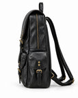 A black leather backpack shown from the side profile against a clean white background, featuring gold-tone hardware and a long shoulder strap.