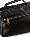 Black textured leather handbag with gold-tone zippers and hardware.