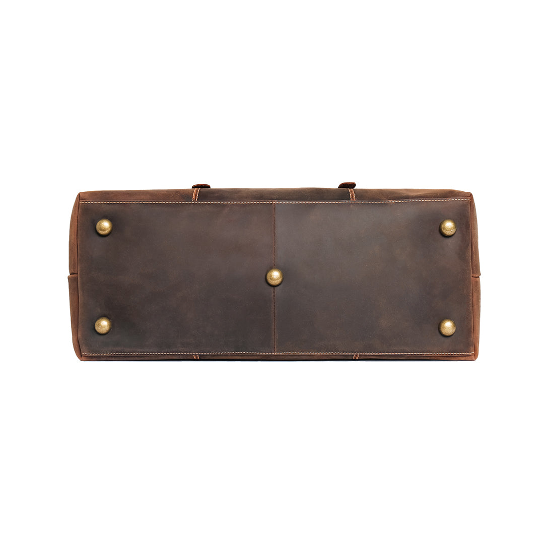 Bottom view of vintage leather duffle bag with protective brass studs, ensuring durability and premium quality