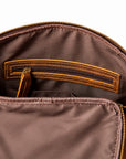 Close-up of the interior of a brown nylon bag with a gold-tone zipper, showing a brown leather interior pocket with contrast stitching and a matching zipper pull.