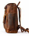 A brown distressed leather backpack shown from a three-quarter angle on a white background, featuring a main zippered compartment, a front slip pocket, and a detachable shoulder strap.