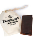 Brown leather wallet with Elwards Leather branded drawstring bag on a white background
