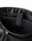 Classic black full-grain leather briefcase inner sleeve with a retaining strap and black lining