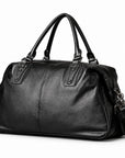 Elegant black full-grain leather duffel bag with twin handles and a stitched center seam.