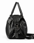 Elegant black full-grain leather duffel bag side view with zip closure and detachable strap.