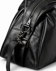 Elegant black full-grain leather duffel bag detail with a detachable swivel clasp and zipper.