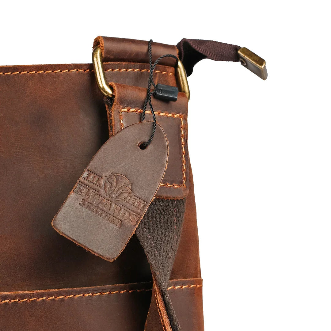 Close-up of golden hardware detailing and Elwards Leather logo on the vintage brown crossbody leather bag.