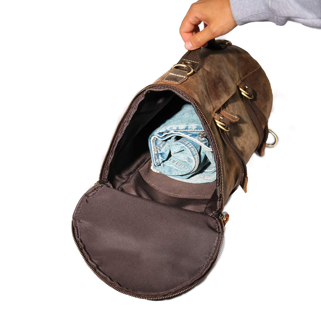 Interior of a high-quality leather backpack with spacious compartments and folded denim for travel packing.