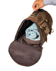 Interior of a high-quality leather backpack with spacious compartments and folded denim for travel packing.