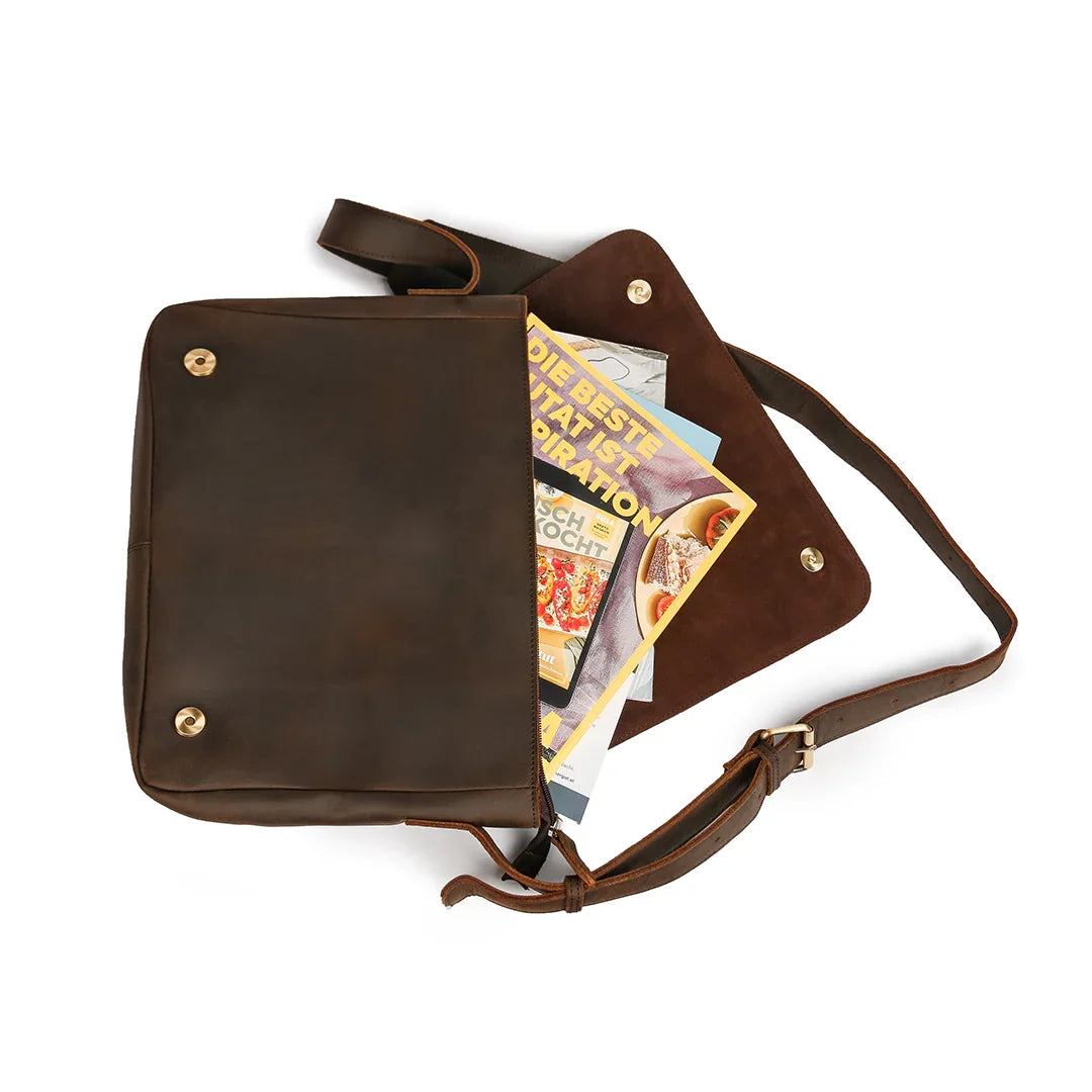 Interior of a vintage leather messenger bag with compartments for books, documents, and a 13-inch laptop