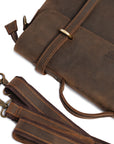 Detailed view of a dark brown leather messenger bag with detachable strap and premium stitching.
