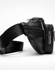A black leather fanny pack with an adjustable black webbing strap, featuring multiple zippered compartments and silver-tone hardware, photographed on a clean white studio background.