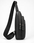 A black pebbled leather crossbody bag with a wide adjustable shoulder strap, shown from a side profile view against a clean white background.