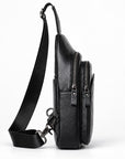 Black pebbled leather crossbody bag with a wide adjustable shoulder strap, shown from a side profile view against a white background.