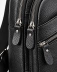 Close-up of a black pebbled leather bag with multiple zippered compartments and silver-tone hardware.
