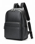 A black leather backpack with a front zippered pocket and adjustable shoulder straps, shown from a three-quarter angle on a white background.