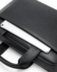 Black pebbled leather laptop briefcase with a top flap pocket holding a silver tablet, shown on a white background.