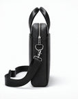 A black pebbled leather briefcase or shoulder bag shown from the side profile on a clean white background. It features a top zipper, silver-tone hardware, and a detachable black shoulder strap.