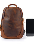 Brown leather men’s sling bag front view with phone for size comparison