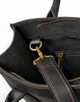 Minimalist black full-grain leather tote strap clip attached to an interior metal ring