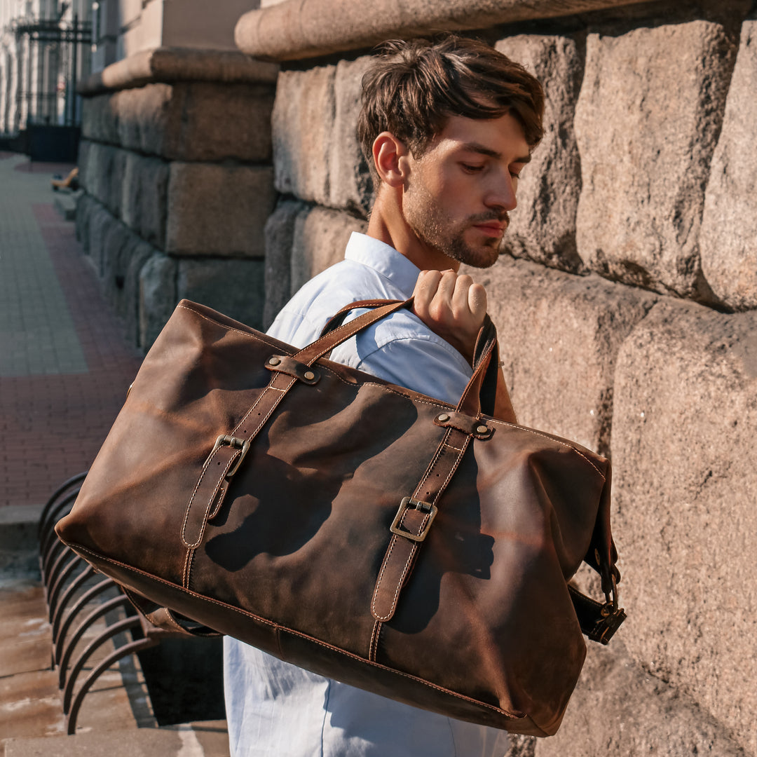 Model carrying a vintage Crazy Horse leather duffle bag, perfect for travel or carry-on, blending style and function.