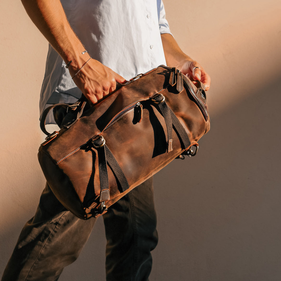 Model holding a vintage leather backpack, highlighting its compact size and elegant design for travel.