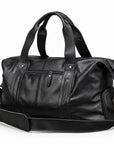 Modern black full-grain leather duffel bag at an angle showing the zippered side pocket.