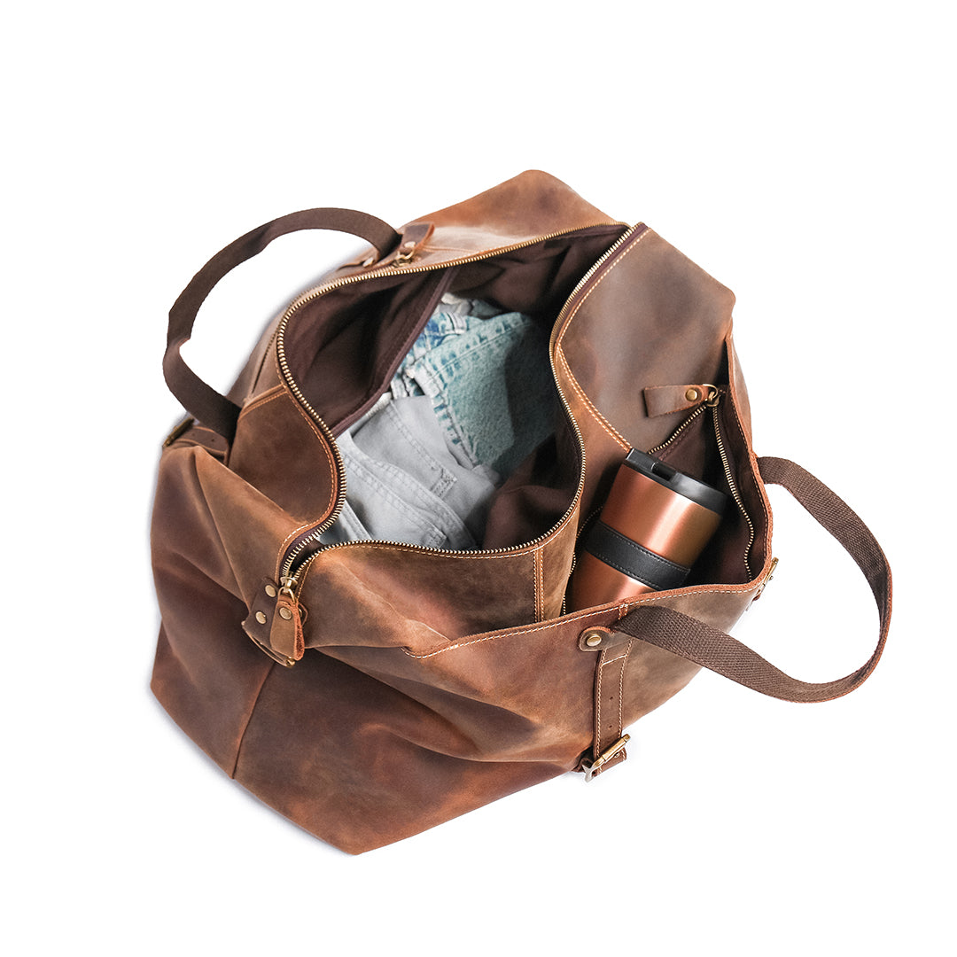Open vintage crazy horse leather duffle bag from a top angle, highlighting its roomy interior and premium zipper details.