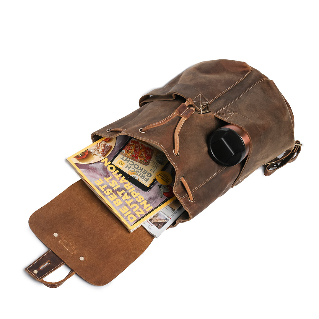 Vintage brown leather backpack filled with books and a thermos, highlighting its capacity and functionality for daily use