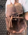 Detailed demonstration of a handcrafted brown leather backpack, showcasing its compartments, durable hardware, and vintage leather.