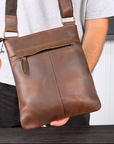 Detailed view of a brown crossbody leather bag with Crazy Horse leather, showcasing vintage design and functionality.