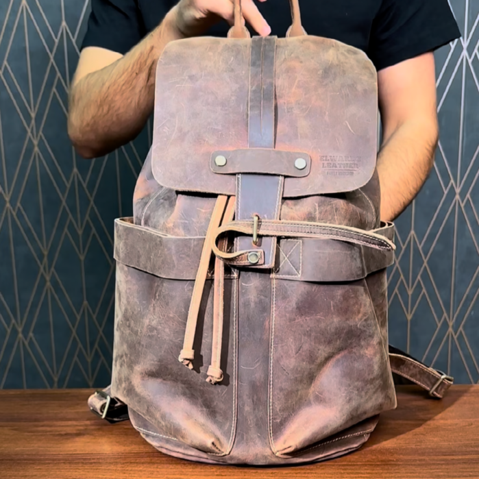 Detailed demonstration of a brown leather backpack, showcasing its compartments, durable hardware, and vintage finish.