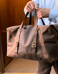 Vintage leather duffle bag in a studio shoot, highlighting its handcrafted Crazy Horse leather and elegant design.