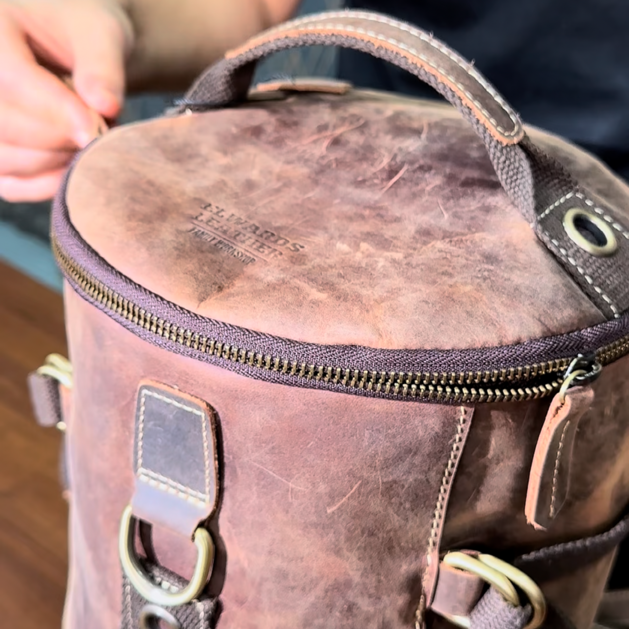Handmade vintage leather backpack on a table, showcasing Crazy Horse leather, durable zippers, and spacious compartments