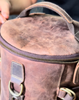 Handmade vintage leather backpack on a table, showcasing Crazy Horse leather, durable zippers, and spacious compartments