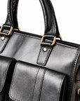 A close-up of the black leather briefcase shows rounded handles, brass-tone rings and riveted leather attachment tabs.