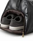 Refined black full-grain leather duffel bag open main compartment with brown fabric lining