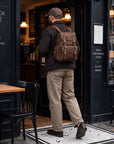 Rugged brown leather rucksack for men with buckle straps, multiple pockets and adjustable shoulder straps for everyday use