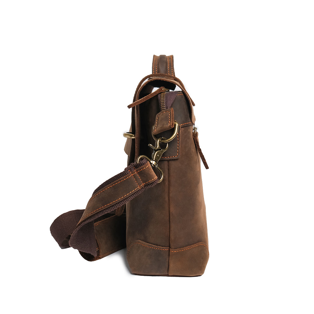 Side view of a handmade dark brown leather bag with adjustable strap and sturdy hardware