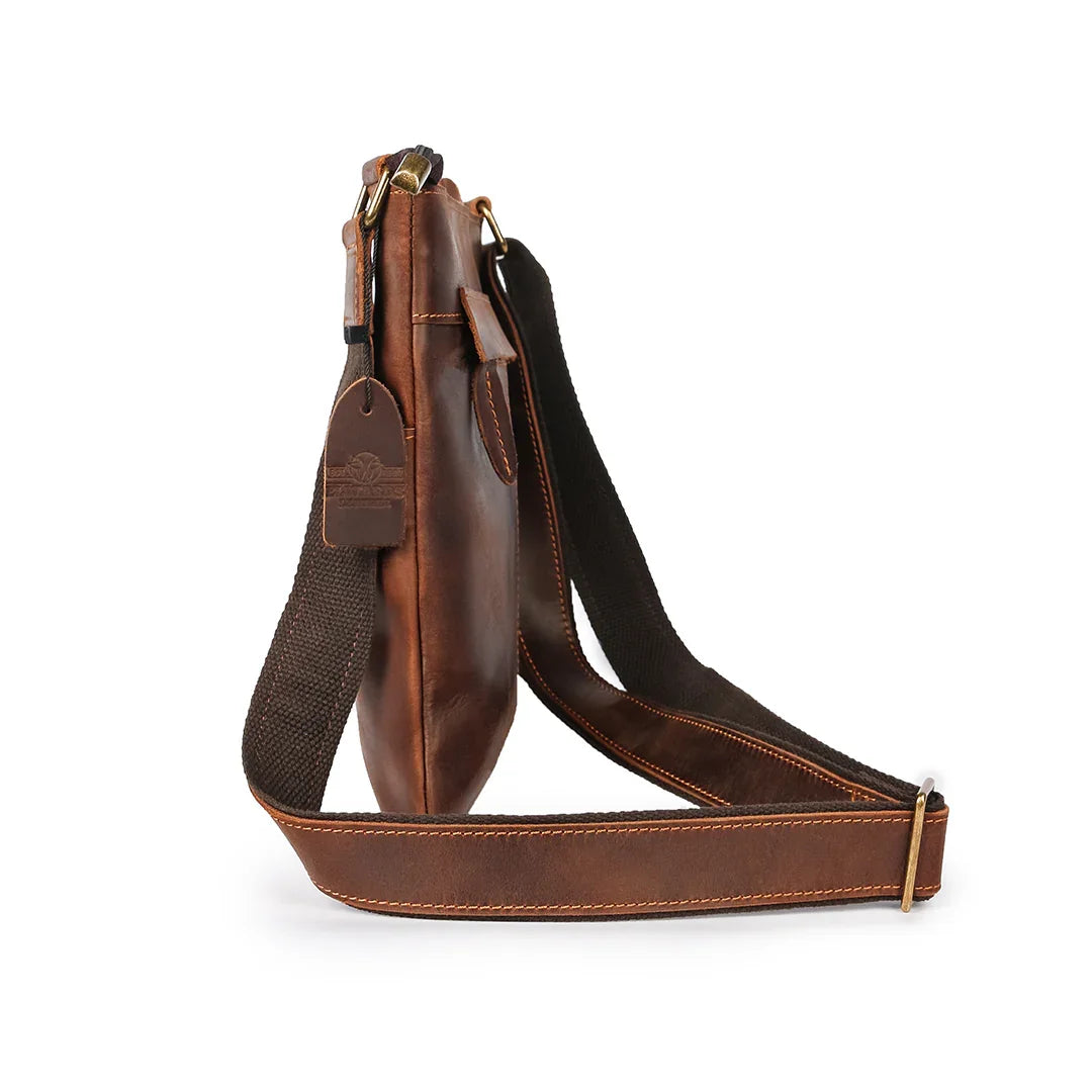 Slim side view of brown leather crossbody bag showcasing compact design and reinforced stitching for everyday use.