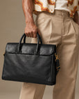 Slim black leather briefcase for men with top handles, flap design and detachable adjustable shoulder strap