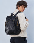 Spacious black leather backpack for men with flap top, buckle straps, large front pocket and zippered side pockets