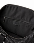 Textured black full-grain leather weekender bag interior with a zip pocket and black fabric lining