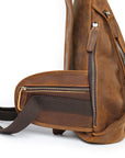 Brown leather sling bag with zippers on a white background