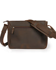 Back view of a dark brown leather shoulder bag with a secure zippered pocket and padded strap for comfort